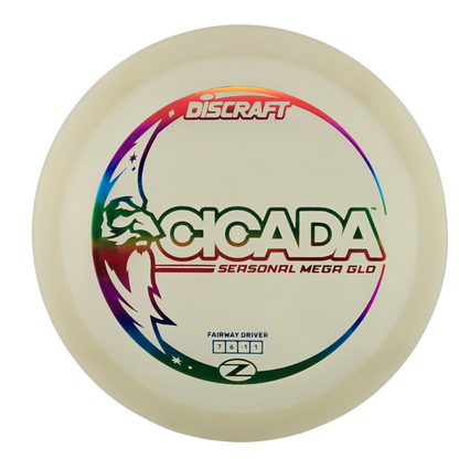 A Discraft Cicada fairway driver disc golf disc, featuring a translucent cream-colored plastic body with a vibrant rainbow graphic and green, red, and black printed text.