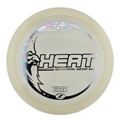 A disc golf disc, specifically a Z-Line Heat Seasonal Mega Glide fairway driver, featuring a translucent off-white plastic body with a black and holographic graphic design on the top.